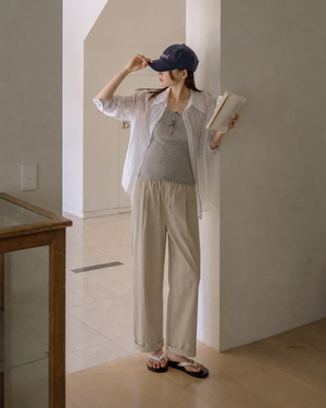 Woman in casual outfit holding a book in a minimal indoor setting