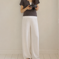 Woman standing in a minimalistic room holding a camera.