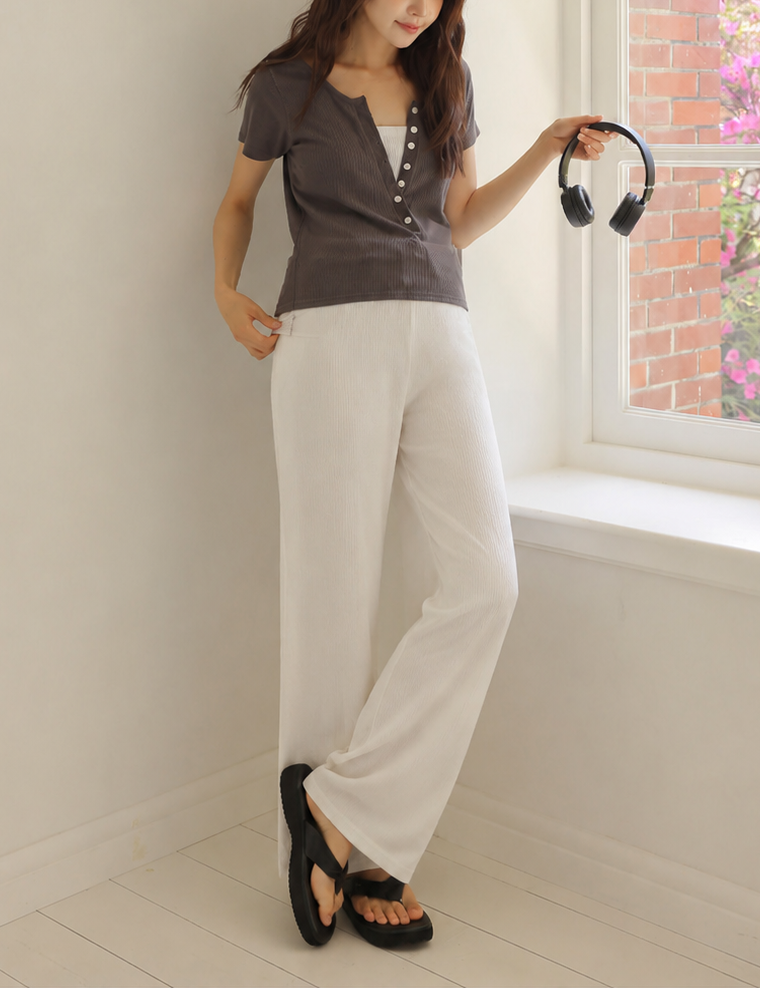 Woman holding headphones in a room with a window showing a garden view
